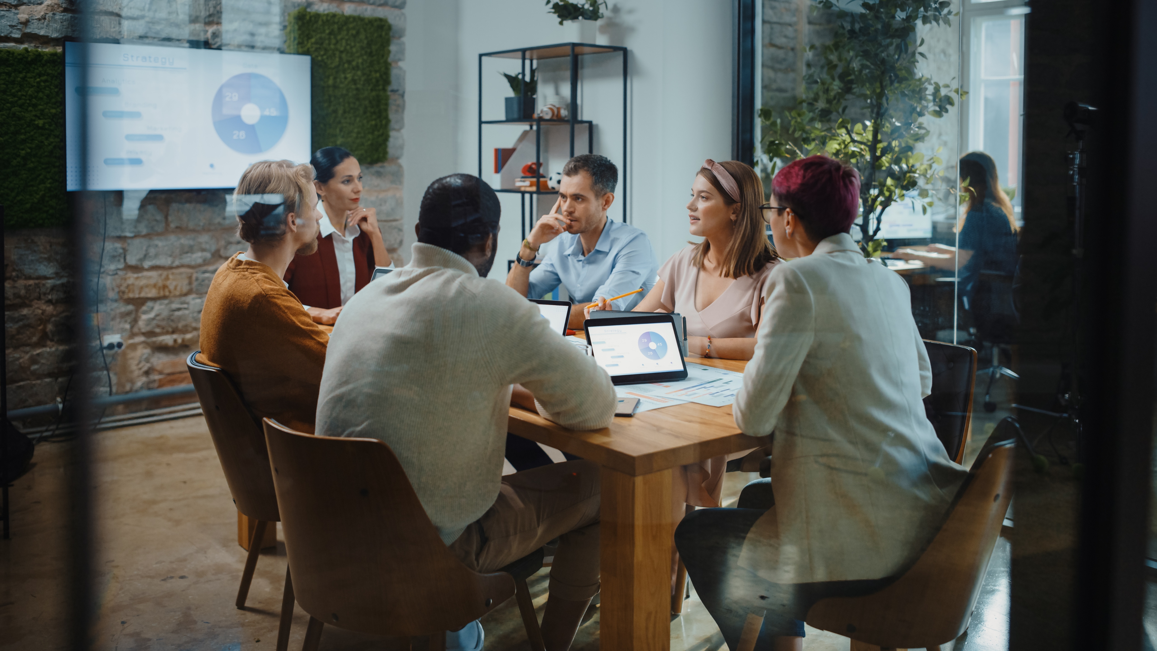 Group of professionals discussing strategy in a modern meeting room.