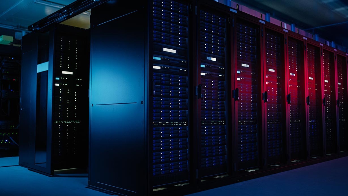 Server room with rows of illuminated server racks.