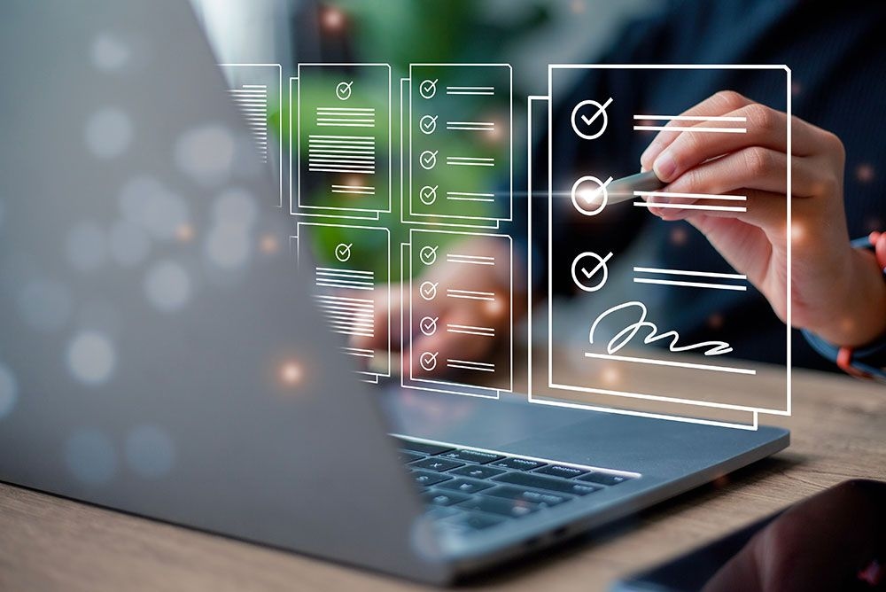 Hand checking digital lists above laptop, illustrating task management